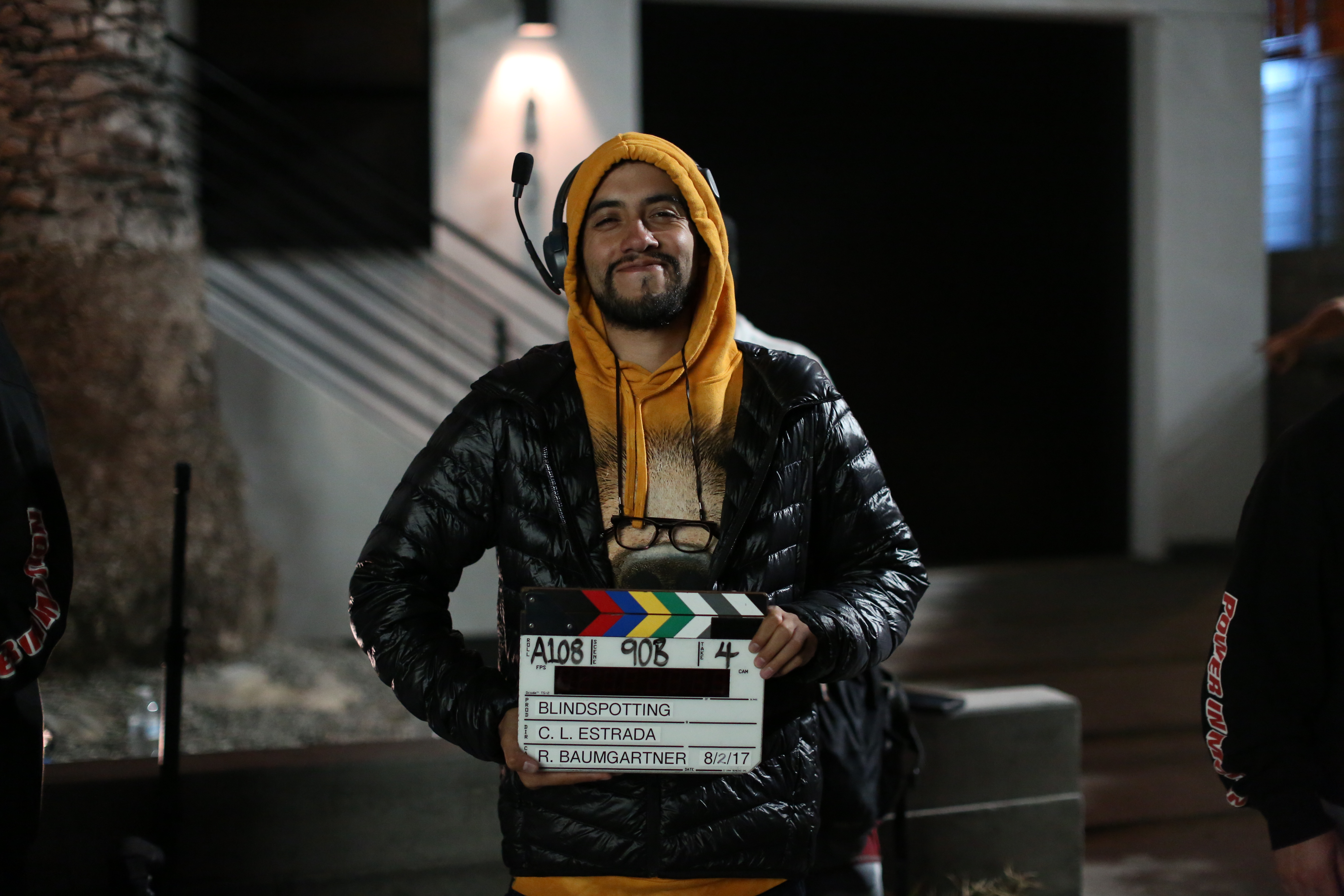 Carlos on set holding a clapperboard.