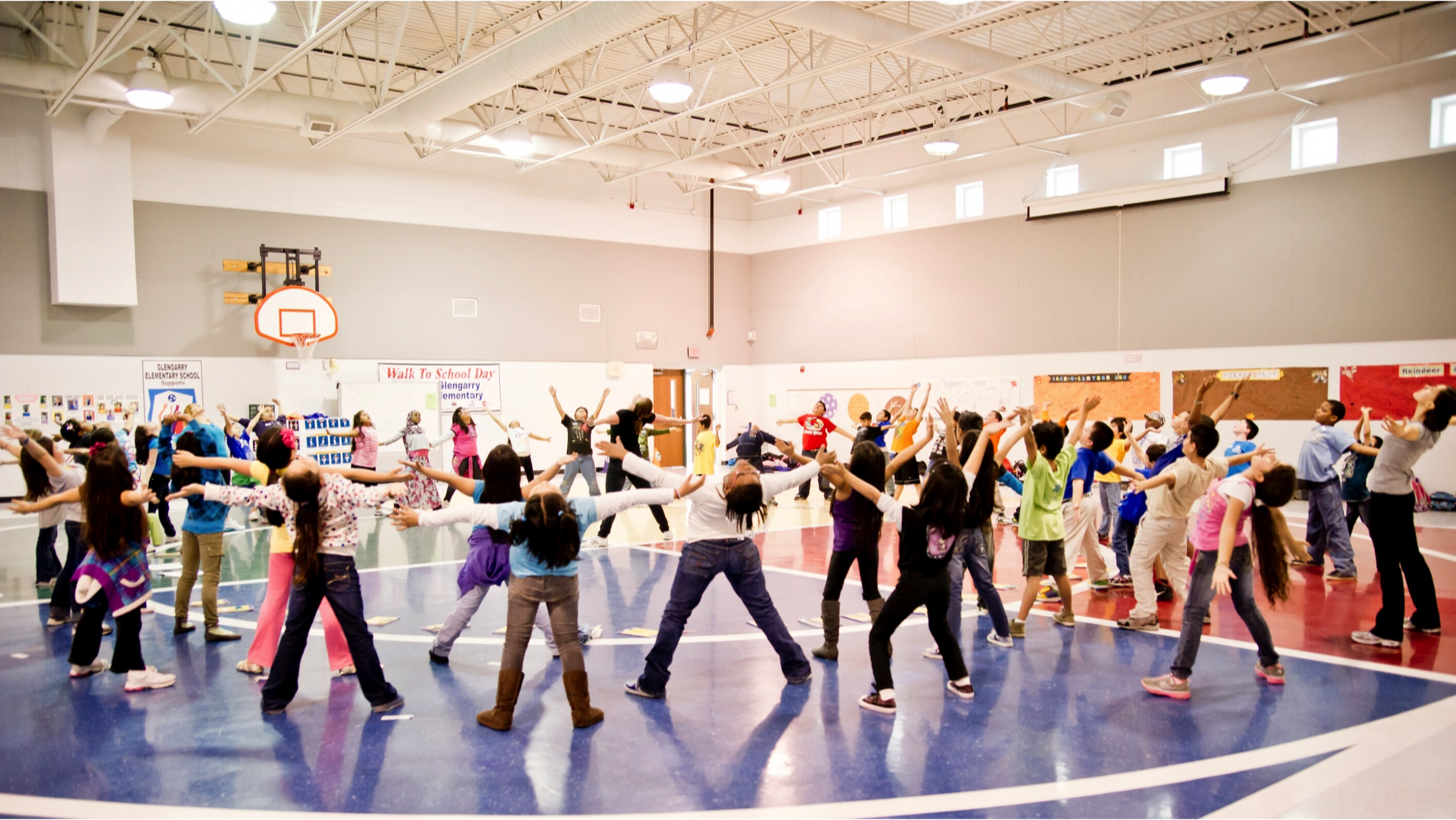 A group of students performing a circle exercise in a gymnasium.