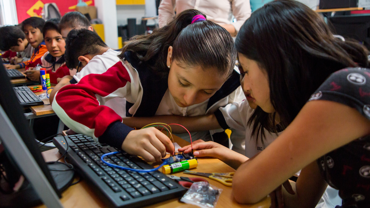 Two girls working on computer components.