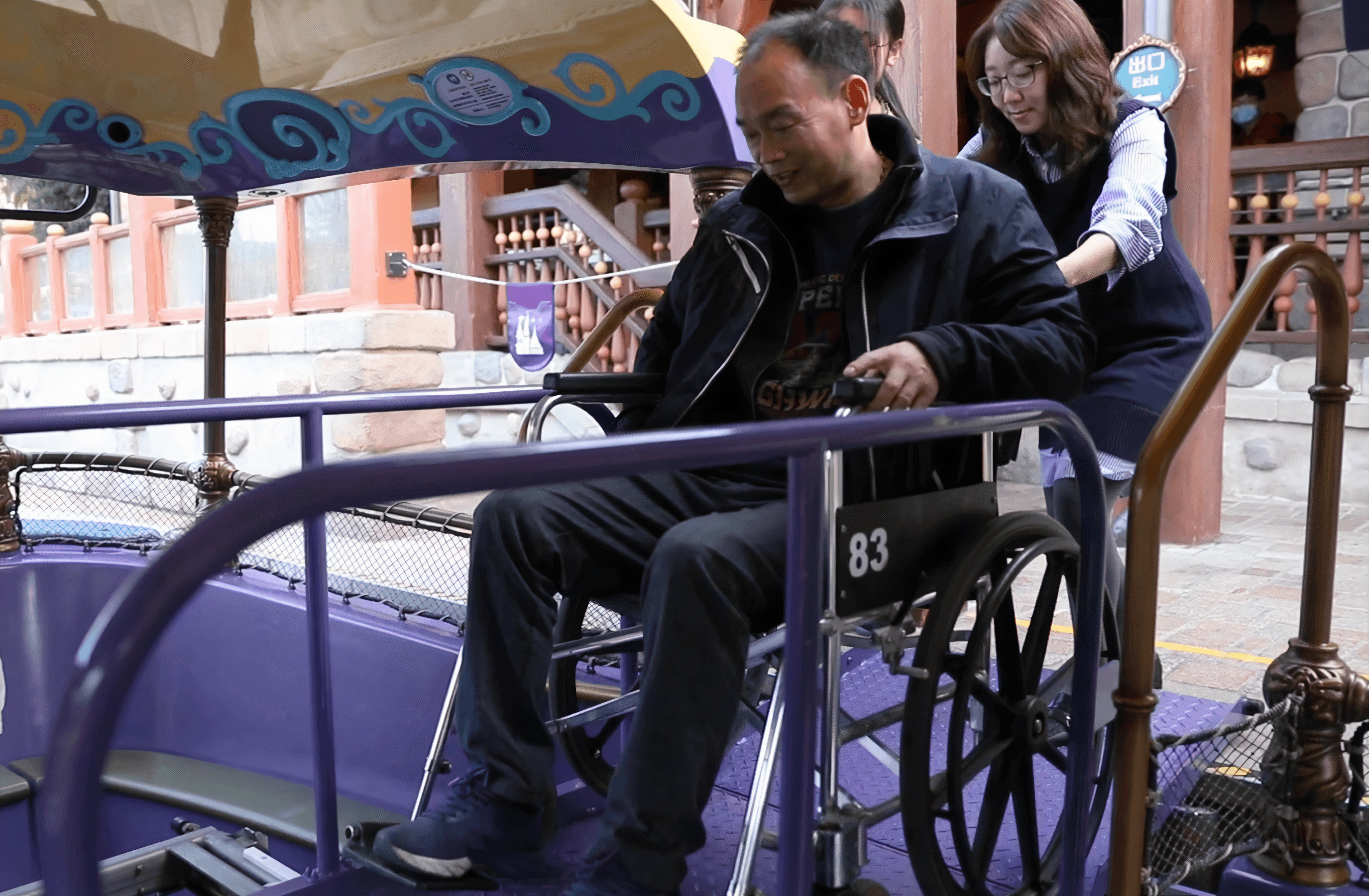 A woman pushing a man in a wheelchair.